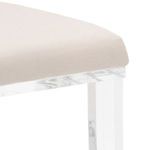 Close-up of muslin seat cushion and clear acrylic chair legs showing fabric texture and transparent frame