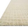 Close-up angle showing the rug’s thick looped wool texture and edge detail with an ivory grid pattern