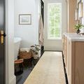 Santa Fe Rug as runner in a bright bathroom with black floor tiles and wooden vanity