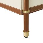 Close-up on dresser leg wrapped in stitched tan leather with brushed brass details