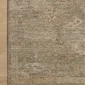 Corner of rug styled on light wood floor, highlighting border details and color shifts