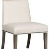 Front angled view showing chair’s padded seat depth and nailhead trim along seat edges