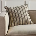 Pillow styled at the corner of a light beige upholstered sofa