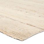 Close-up angled view showing soft wool texture and light beige fringed edge of rug
