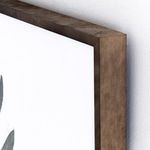 Close-up detail showing edge of thick brown frame against white wall