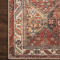 Detailed close-up on corner of rug showing intricate pattern and edge binding on wood floor