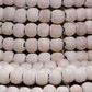 Close-up detail of natural mango wood beads strung on metal wire forming lamp base