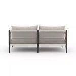 Sherwood sofa back view showing dark aluminum frame and tightly woven textured neutral straps