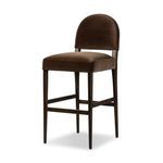 Three-quarter angle view showing the stool’s curved backrest and square cushioned seat