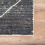 Close-up of Satellite Rug corner showing looped texture and edge stitching detail