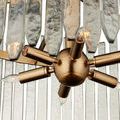 Close-up showing hammered texture on individual curved glass bars and visible brass mounting hardware