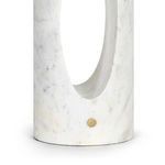 Close-up showing oval cutout and brass knob on lower part of white marble base