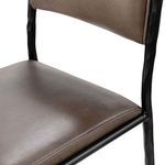 Close-up of leather backrest attached to textured hammered metal frame