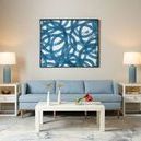Two Polo side tables flanking a blue sofa with lamps and a light rug in a living room setting