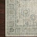 Close-up of the rug corner showing detailed floral border pattern against dark hardwood floor