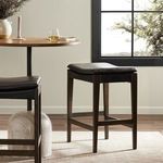 Aya Stool shown in a living space near a rug and wood pedestal table showing use context