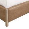 Close-up detail of tan upholstered footboard corner with visible wood legs