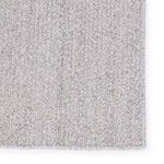 Detailed close-up of rug's textured weave pattern and stitched border edge