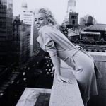 Tighter crop focusing on Marilyn Monroe leaning against the rooftop wall in grayscale