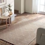 Room setting with rug on wood floor beside chair and natural light through window