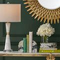 Close-up of Fossey Object on console table, showing swirling green, black, white pattern and surrounding books and lamp