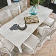 Top-down view of Miller Dining Table with decorative vase and tableware on top and chairs around