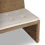 Close-up of rattan armrest corner with attached tufted beige cushion