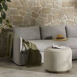 Sinclair Outdoor Ottoman styled in outdoor living space next to grey sectional and beige stone wall