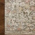 Top-down close-up of rug corner on hardwood floor highlighting dense weave and muted floral pattern