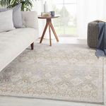 Rug shown in a natural sunlight room with gray sofa, side table, and styled accents