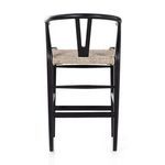 Side view emphasizing curved black teak backrest with V support and wicker seat