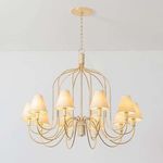 Warrensburg Chandelier with swooping vintage gold leaf metal arms and linen fabric shades, featuring abaca-wrapped details.