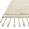 Side view showing thick shag pile height and braided fringes on oatmeal ivory rug edge