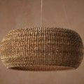 Boucle Chandelier hanging against warm textured brown wall