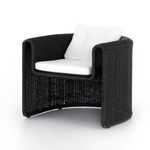 Coal-colored woven outdoor chair with curved Seventies-inspired frame and white tufted cushions