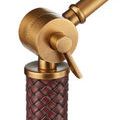 Close-up focusing on the antique brass ratchet mechanism and woven rust faux leather wrapping