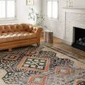 Jocelyn Navy Multi Rug styled in a bright living room under a brown tufted leather sofa