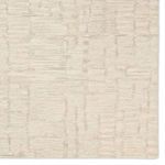 Top down close detail of rug's abstract striped pattern with varying pile heights in taupe and cream