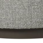 Close-up of seam and fabric meeting dark brown base at bottom edge of ottoman
