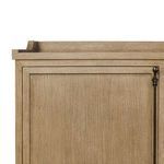 Close-up on framed panel door with aged bronze hardware and gallery top corner detail
