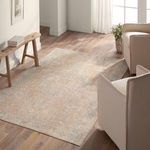 Rug styled in a wooden floor living room with light beige armchairs and natural light