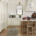 Narrow runner version of rug placed in bright kitchen with island and wooden chairs