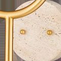 Close-up of the round travertine wall mount with two brass brads fastening the metal stems
