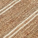 Close-up of chunky hand-woven natural jute fibers showing knot texture and white stripe detail