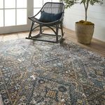 Angled view of rug with focus on central diamond medallion, partially under black rocking chair