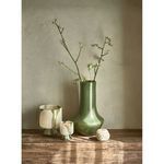 Camou Olive glass shown in styled room context with matching vase, candle holder, and decorative object on wooden surface
