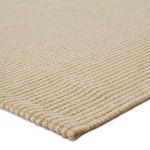 Close-up showing thick woven texture and edge detail of beige jute and wool fibers