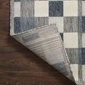 Rug corner flipped to show tightly woven backing on hardwood floor