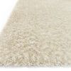 Angled close-up focusing on the fiber texture and thickness of the ivory shag rug