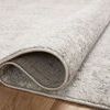 Corner fold showing plush pile height and woven fabric backing on hardwood floor